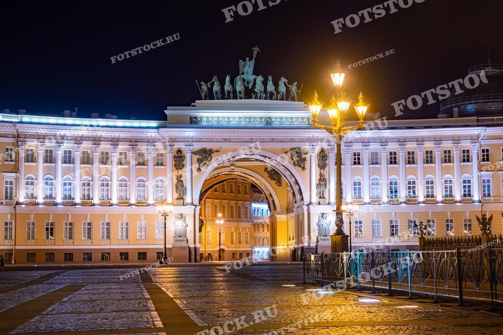 На фотографии изображена арка Главного штаба в Санкт-Петербурге в ночное время. Подсветка подчеркивает архитектурные детали арки и здания, создавая эффектный ночной вид. Дворцовая площадь пустынна, что добавляет фотографии атмосферу величественного спокойствия. Арка Главного штаба является символом исторической и культурной значимости города.